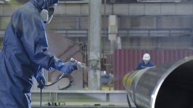 Erkek holding boya tabancası ve boyalı çelik. Adam boya boru atomizer