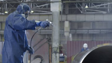 Erkek holding boya tabancası ve boyalı çelik. Adam boya boru atomizer