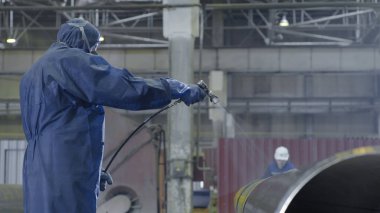 Erkek holding boya tabancası ve boyalı çelik. Adam boya boru atomizer