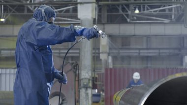 Erkek holding boya tabancası ve boyalı çelik. Adam boya boru atomizer