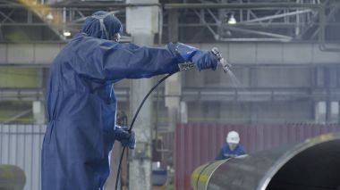 Erkek holding boya tabancası ve boyalı çelik. Adam boya boru atomizer