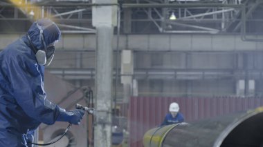 Erkek holding boya tabancası ve boyalı çelik. Adam boya boru atomizer