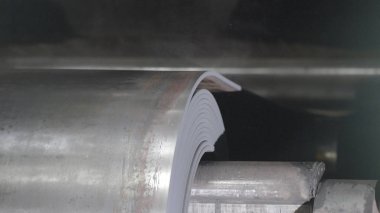 Metal bant makinesi yakın çekim haddeleme hareket ediyor. Çalışırken sayfa haddehane