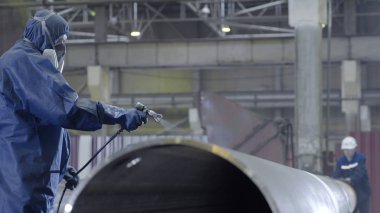 Erkek holding boya tabancası ve boyalı çelik. Adam boya boru atomizer