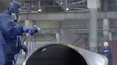 Erkek holding boya tabancası ve boyalı çelik. Adam boya boru atomizer