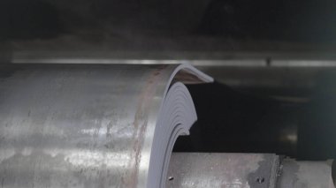 Metal bant makinesi yakın çekim haddeleme hareket ediyor. Çalışırken sayfa haddehane