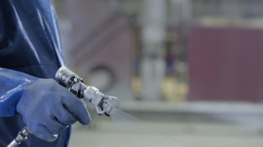 Endüstriyel boyutu sprey boyama ve kaplama sanayi için kullanılan silah tutan el kol. Erkek el boya sprey, closeup tutarak