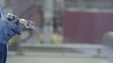 Endüstriyel boyutu sprey boyama ve kaplama sanayi için kullanılan silah tutan el kol. Erkek el boya sprey, closeup tutarak