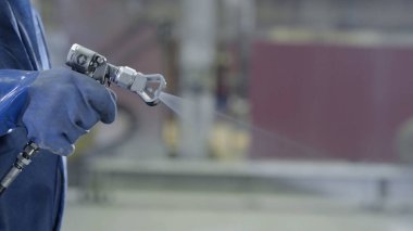 Endüstriyel boyutu sprey boyama ve kaplama sanayi için kullanılan silah tutan el kol. Erkek el boya sprey, closeup tutarak