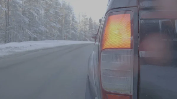 Phare à proximité sur les routes enneigées. La voiture roule sur une route enneigée — Photo