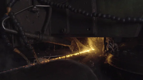 Welder complete with personal protective equipment is perform pipe welding in dark area using Automatic Welding System. Welding sparks spreading everywhere. Automat welding pipe production — Stock Photo, Image