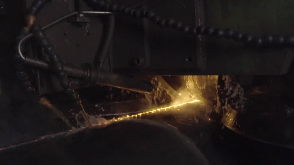 Welder complete with personal protective equipment is perform pipe welding in dark area using Automatic Welding System. Welding sparks spreading everywhere. Automat welding pipe production — Stock Photo, Image