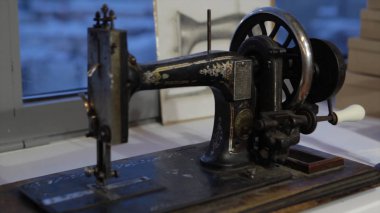 Dikiş makinesi, dikiş makinesi ve kadın boyuyla terzi. Antika dikiş makinesi Franklin. Genç kadın dikiş makinesi üzerinde çalışan koruyucu yüz maskesi takıyor. Moda