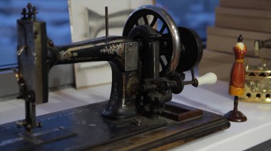 Dikiş makinesi, dikiş makinesi ve kadın boyuyla terzi. Antika dikiş makinesi Franklin. Genç kadın dikiş makinesi üzerinde çalışan koruyucu yüz maskesi takıyor. Moda