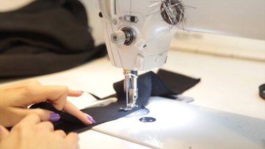 Dikiş makinesi, dikiş makinesi ve kadın boyuyla terzi. Antika dikiş makinesi Franklin. Genç kadın dikiş makinesi üzerinde çalışan koruyucu yüz maskesi takıyor. Moda