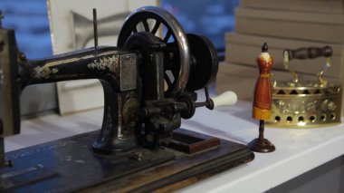 Dikiş makinesi, dikiş makinesi ve kadın boyuyla terzi. Antika dikiş makinesi Franklin. Genç kadın dikiş makinesi üzerinde çalışan koruyucu yüz maskesi takıyor. Moda