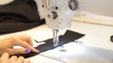 Dikiş makinesi, dikiş makinesi ve kadın boyuyla terzi. Antika dikiş makinesi Franklin. Genç kadın dikiş makinesi üzerinde çalışan koruyucu yüz maskesi takıyor. Moda