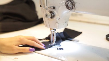 Dikiş makinesi, dikiş makinesi ve kadın boyuyla terzi. Antika dikiş makinesi Franklin. Genç kadın dikiş makinesi üzerinde çalışan koruyucu yüz maskesi takıyor. Moda