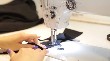 Dikiş makinesi, dikiş makinesi ve kadın boyuyla terzi. Antika dikiş makinesi Franklin. Genç kadın dikiş makinesi üzerinde çalışan koruyucu yüz maskesi takıyor. Moda