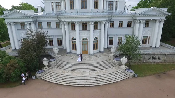 Estudio aéreo de los novios que bailan en el palacio del jardín. Gran palacio blanco o vista al castillo. Volando sobre el palacio en el gran patio. Vista de San Petersburgo. La pareja camina cerca de la — Foto de Stock