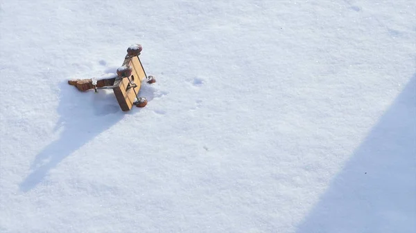 Kinder speelgoed liggend in de sneeuw en de vrouw nemen. Kleine sneeuwpop speelgoed In de sneeuw. Hand nemen Christmas speelgoed Retro kleurrijke vak Winter sneeuw. Vintage ding op witte baground. Winter — Stockfoto