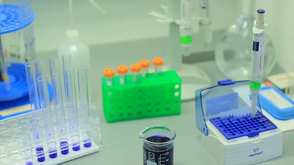 De nombreuses éprouvettes dans un laboratoire de recherche d'une université. photo symbolique pour l'apprentissage et la recherche. Verre dans un laboratoire chimique rempli de liquide coloré pendant la réaction . — Photo
