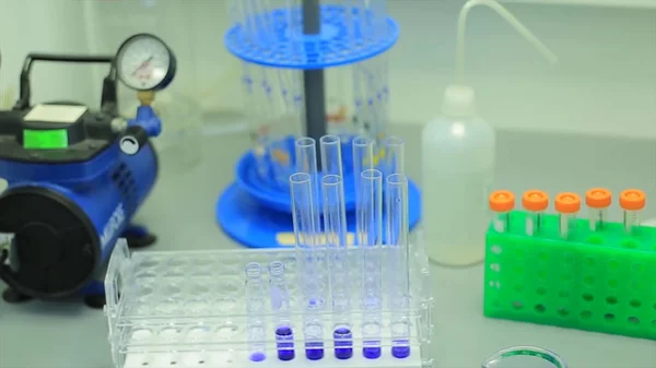 多くは大学の研究室でのテストでチューブをテストします。学習と研究のための象徴的な写真。化学研究所に反応中に色付きの液体で満たされたガラスします。. — ストック写真
