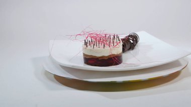 Bir plaka üzerinde üç kat kremalı pasta. Kremalı pasta çikolata kırıntıları ve çikolata saman ile dekore edilmiş üç kat ile