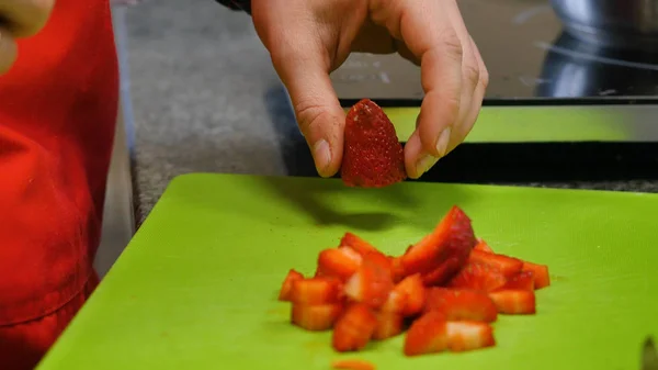 Chef mano e coltello Affettare fragola fresca sul tagliere — Foto Stock
