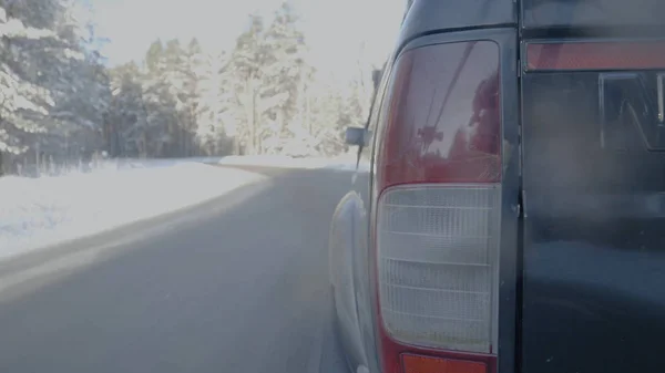 Фара крупным планом на снежных дорогах. Автомобиль едет по заснеженной дороге — стоковое фото