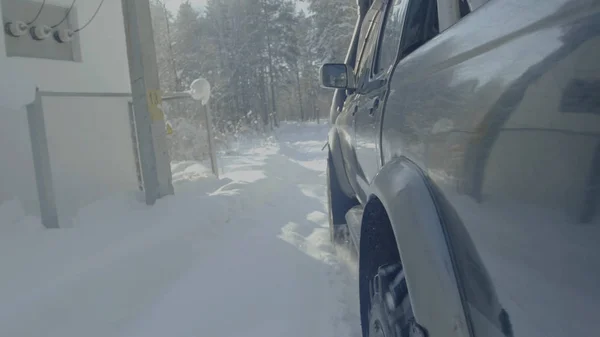 Promenades en voiture sur une route forestière d'hiver. Une voiture dans une route enneigée entre les arbres — Photo