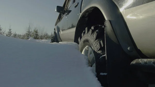 Conduite de SUV voiture en hiver sur la route forestière avec beaucoup de neige. Une voiture coincée dans les bois. Gros plan — Photo