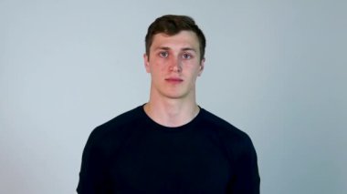 Mavi t-shirt, atış, stüdyo erkekte hipster izole. Beyaz arka plan üzerinde izole mavi t-kısa giymiş yakışıklı genç bir adam portresi