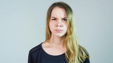 Genç güzel kadın beyaz bir arka plan üzerinde kızgındır. Kızgın genç kadın. Ağır çekim