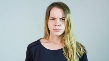 Genç güzel kadın beyaz bir arka plan üzerinde kızgındır. Kızgın genç kadın. Ağır çekim