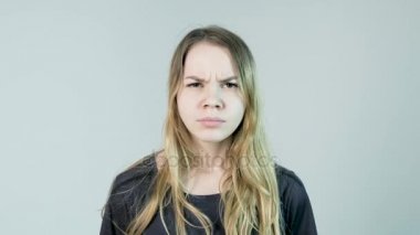 Genç güzel kadın beyaz bir arka plan üzerinde kızgındır. Kızgın genç kadın