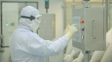 İlaç üretim çalışan bir işçi iş başında. Robotik Kol ilaç fabrikasında paketleme hattı, ampul kaldırma. İlaç endüstrisi. Ampul paketleme makinesi