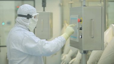 İlaç üretim çalışan bir işçi iş başında. Robotik Kol ilaç fabrikasında paketleme hattı, ampul kaldırma. İlaç endüstrisi. Ampul paketleme makinesi