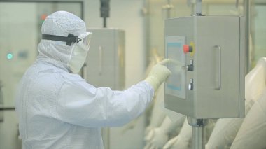 İlaç üretim çalışan bir işçi iş başında. Robotik Kol ilaç fabrikasında paketleme hattı, ampul kaldırma. İlaç endüstrisi. Ampul paketleme makinesi