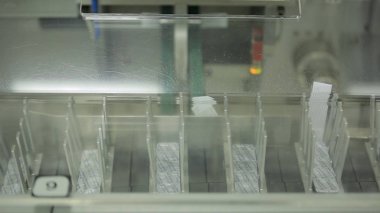 iç hapları kutu ambalaj için bir ilaç endüstrisi ekipman. Otomatik optik inceleme makinesi, inceler şişeleri ve sıvı ve konteyner Defektlerde parçacıklar için ampul.