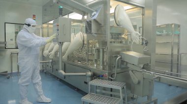 İlaç endüstrisi. Hap ilaç fabrikasında paketleme kalitesini teftiş erkek fabrika işçisi. Otomatik bant ambalaj ve dolum ilaçların oluşturmak için. fabrikada kontrol
