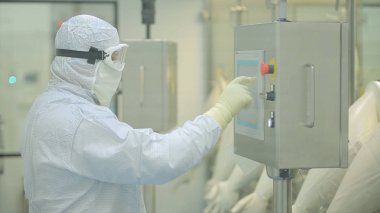 İlaç üretim çalışan bir işçi iş başında. Robotik Kol ilaç fabrikasında paketleme hattı, ampul kaldırma. İlaç endüstrisi. Ampul paketleme makinesi