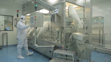 İlaç endüstrisi. Hap ilaç fabrikasında paketleme kalitesini teftiş erkek fabrika işçisi. Otomatik bant ambalaj ve dolum ilaçların oluşturmak için. fabrikada kontrol