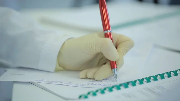 Mittelteil des Arztschreibens auf Papier in der Klinik. Nahaufnahme von Patient und Arzt, die Notizen machen. Arzt schreibt ein Rezept. Physiotherapeut schreibt auf Klemmbrett in der Klinik. Ärztin schreibt eine — Stockfoto