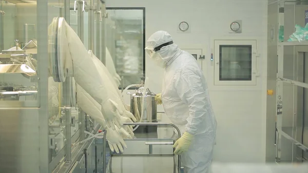 Pharmaceutical industry. Male factory worker inspecting quality of pills packaging in pharmaceutical factory. Automatic tape to create packaging and filling of medicines. control in the factory of