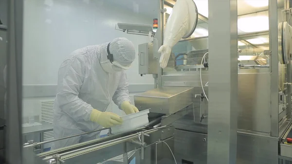 Industria farmacéutica. Trabajador de fábrica masculino que inspecciona la calidad del embalaje de las píldoras en fábrica farmacéutica. Cinta automática para crear envases y rellenos de medicamentos. control en la fábrica de — Foto de Stock