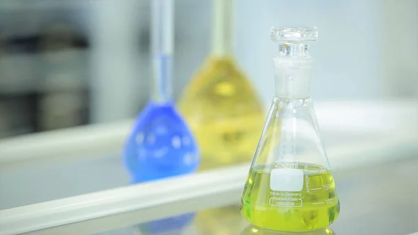 Flacons chimiques avec liquide vert et bleu sur fond blanc. Tubes à essai avec réactif chimique coloré. Verrerie de laboratoire. Laboratoire chimique. Cocus sélectif. Bokeh. scientifique et médical — Photo