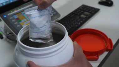 Kimyasal laboratuvar masada beyaz etiketlenmemiş plastik depo kapak açılarak kimyasal bilim adamı