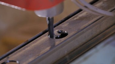 Delik içine metal delinmiştir. Delme closeup metal atölyesinde. Çalışan matkap tezgah matkap ile yassı çelik plaka. Ağır çekimde sanayi
