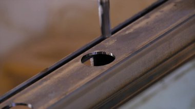 Delik içine metal delinmiştir. Delme closeup metal atölyesinde. Çalışan matkap tezgah matkap ile yassı çelik plaka. Ağır çekimde sanayi